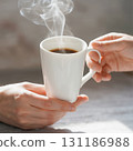 Hands Holding a Steaming Cup of Coffee 131186988