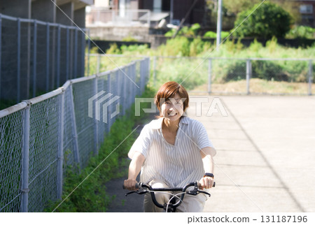 <People> Smiling woman riding a bicycle 131187196