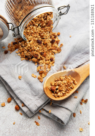Granola pouring from jar on light background Granola pouring from jar on light background 131188921