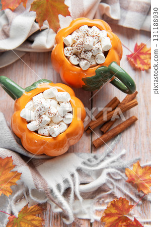 Pumpkin mugs with hot chocolate and marshmallows for autumn comfort 131188930