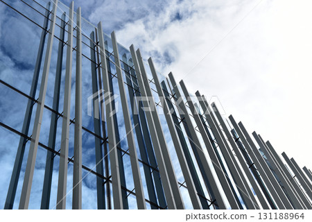 Skyscraper from a low angle view, glass window facade window against blue sky Skyscraper from a low angle view, glass window facade window against blue sky 131188964