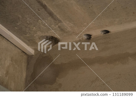 Holes in cement ceiling for sewer pipes in construction in apartment building. Holes in cement ceiling for sewer pipes in construction in apartment building. 131189099