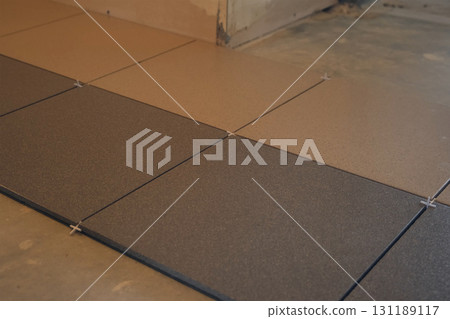 Installation of ceramic tile on floor in flat in building under construction. 131189117