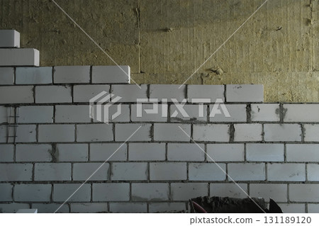 Construction works of laying bricks blocks creating walls in building. 131189120
