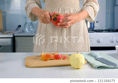 Woman peeling apples cooking food dish on kitchen at home, hands close-up. Woman peeling apples cooking food dish on kitchen at home, hands close-up. 131189275