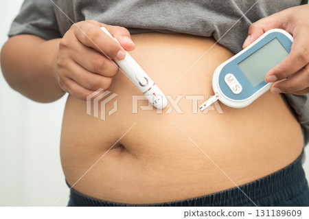 Asian woman injecting herself diabetes injecting insulin in stomach at home. Asian woman injecting herself diabetes injecting insulin in stomach at home. 131189609