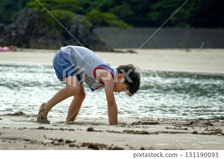 <素材> 黃昏時分，男孩在海邊玩沙 131190093