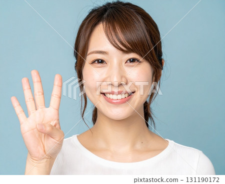 一位日本年輕女子用右手比出數字“4” 131190172