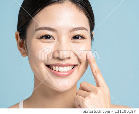 Smiling Japanese woman pointing at her bare skin Smiling Japanese woman pointing at her bare skin 131190187