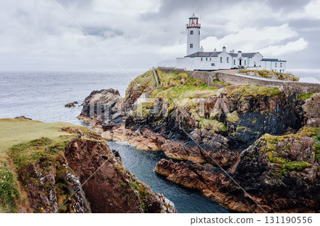 A lighthouse stands on a cliff overlooking the sea, guiding ships safely.. A lighthouse stands on a cliff overlooking the sea, guiding ships safely.. 131190556