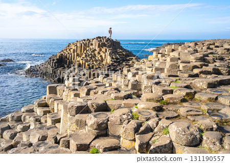 A person explores the Giant's Causeway, a unique geological formation in Northern Ireland.. 131190557