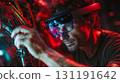 Man in futuristic VR headset with holographic display surrounded by red neon lights in cyberpunk tech environment. Digital innovation concept 131191642