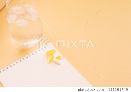 Supplements on notebook with iced water and copy space 131191749