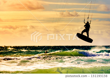 Kite surfer riding waves. Kiteboarding sport. 131193138