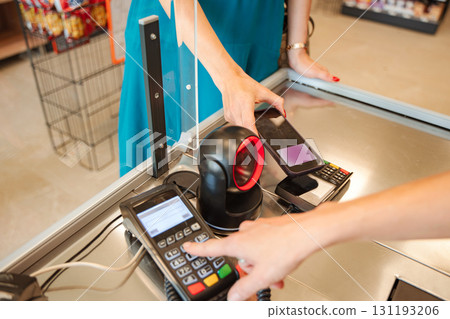 Customer paying with smartphone at supermarket checkout Customer paying with smartphone at supermarket checkout 131193206