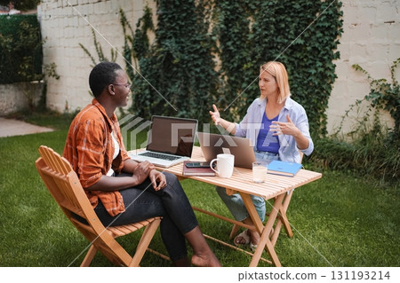 Two Businesswomen Working on Laptops in a Garden 131193214