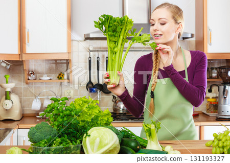 Woman in kitchen with green vegetables 131193327