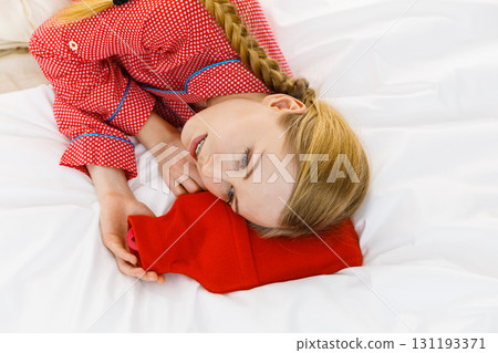 Woman sleeping with warm red hot water bottle Woman sleeping with warm red hot water bottle 131193371