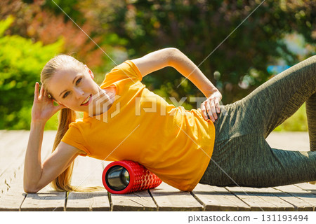 Girl doing exercises outdoor, using roller 131193494