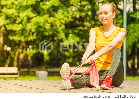 Girl doing exercise outdoor, using resistance fit band. Girl doing exercise outdoor, using resistance fit band. 131193496