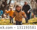 Young boy is running through a field with his father behind him 131193581