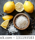 Bowl of salt and pepper sits on a counter with a lemon and a lemon slice 131193583