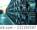 Row of black barrels are stacked on top of each other 131193587