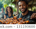 Man is grilling chicken on a barbecue grill 131193600