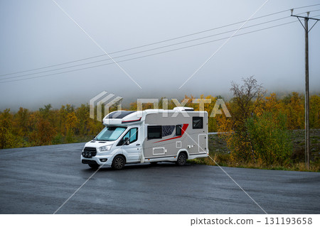 Motorhome parked on asphalt road with autumn forest background Motorhome parked on asphalt road with autumn forest background 131193658