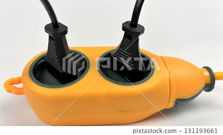 Outdoor waterproof orange power extension socket with two black plugs connected, heavy duty electric splitter for garden, construction, camping, energy distribution, close-up on white background Outdoor waterproof orange power extension socket with two black plugs connected, heavy duty electric splitter for garden, construction, camping, energy distribution, close-up on white background 131193661