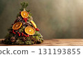 A small, decorated Christmas tree with dried orange slices, red berries, and pinecones on blurred background. Christmas decor and craftwork, eco friendly, sustainable concept. Place for text. 131193855