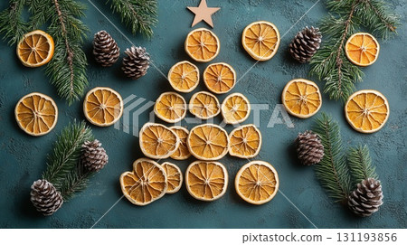 Christmas tree shape created using dried orange slices, pine cones, and fir branches on a textured background. Christmas decor and craftwork, eco friendly, sustainable concept. 131193856