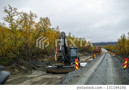 Excavator working on road construction site in autumn forest Excavator working on road construction site in autumn forest 131194298