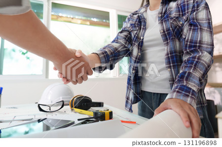 Engineers shaking hands over project agreement in office Engineers shaking hands over project agreement in office 131196898