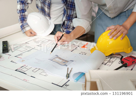 Engineers reviewing construction plans in modern workspace Engineers reviewing construction plans in modern workspace 131196901