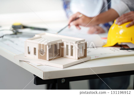Architectural model on table with engineers discussing plans 131196912