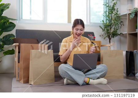 Online shopping. Woman enjoying her shopping experience with laptop and credit card. 131197119