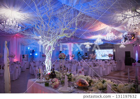 Elegant wedding reception with decorated tables and beautiful lighting in a banquet hall 131197632