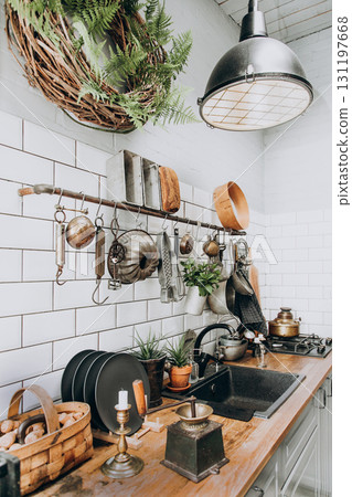 Cozy kitchen with vintage decor and greenery in a warm setting Cozy kitchen with vintage decor and greenery in a warm setting 131197668