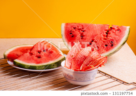 Winter supplies: slices of dried watermelon with fresh pieces on yellow background Winter supplies: slices of dried watermelon with fresh pieces on yellow background 131197754