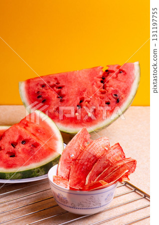 Winter supplies: slices of dried watermelon with fresh pieces on yellow background Winter supplies: slices of dried watermelon with fresh pieces on yellow background 131197755