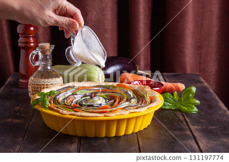 Process of cooking vegetable spiral tart with zucchini, eggplant, carrots, bell pepper, basil in silicone baking dish. Process of cooking vegetable spiral tart with zucchini, eggplant, carrots, bell pepper, basil in silicone baking dish. 131197774