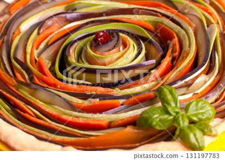 Process of cooking vegetable spiral tart with zucchini, eggplant, carrots, bell pepper, basil in silicone baking dish Process of cooking vegetable spiral tart with zucchini, eggplant, carrots, bell pepper, basil in silicone baking dish 131197783
