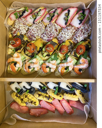 Box with small sandwiches with cold cuts, grilled vegetables, cheese and seafood. Charcuterie boards to order Box with small sandwiches with cold cuts, grilled vegetables, cheese and seafood. Charcuterie boards to order 131197834