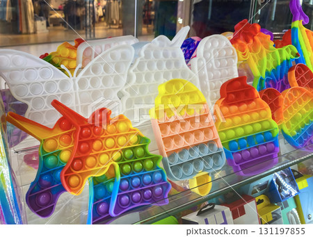 A lot of anti-stress toys Pop It on the shop window in the shopping center 131197855