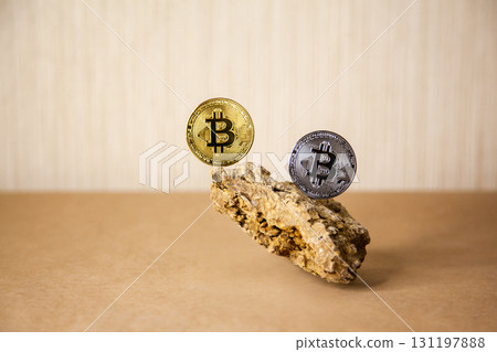 Gold and silver Bitcoin Coins balances on natural stones on light background. Blockchain cryptocurrency, store of value 131197888