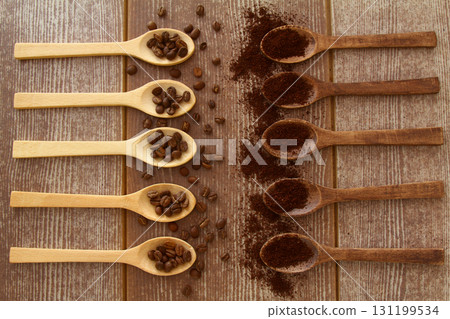 Coffee beans and ground coffee in wooden spoons on brown background. Flat lay. 131199534