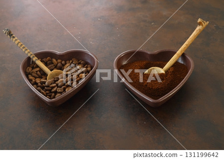 Roasted coffee beans in heart shaped bowl on dark background. Love coffee concept. Top view flat lay 131199642