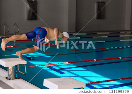 Male swimmer diving into pool in dynamic start motion 131199869