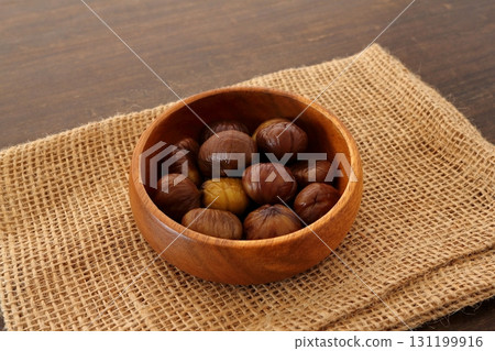 Peeled sweet chestnuts served on wooden table background Peeled sweet chestnuts served on wooden table background 131199916